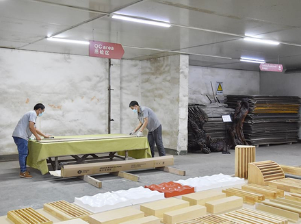 Workers are collaborating in the workshop to assemble and process wooden pieces, showcasing their professional skills.