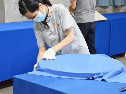 A worker is skillfully sanding wooden pieces, focusing on achieving a smooth surface.