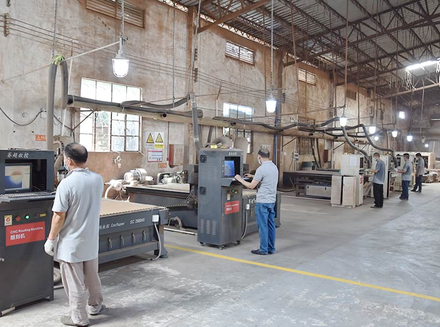 Workers and machinery in a workshop processing wood for innovative and customized products.