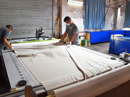 A worker is using large machinery to precisely cut wooden pieces, ensuring each piece meets craftsmanship requirements.