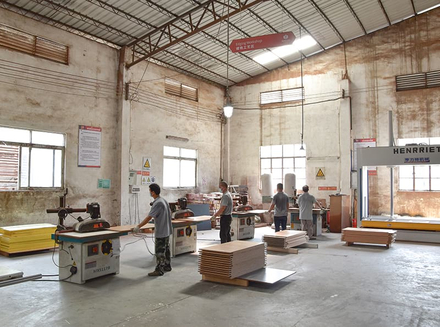 Workers using tools to manually process wood for unique designs or customization.
